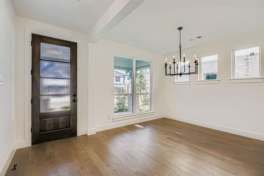 Foyer entrance with wood-type flooring, plenty of natural light, a chandelier, and beam ceiling Foyer entrance with wood-type flooring, plenty of natural light, a chandelier, and beam ceiling
