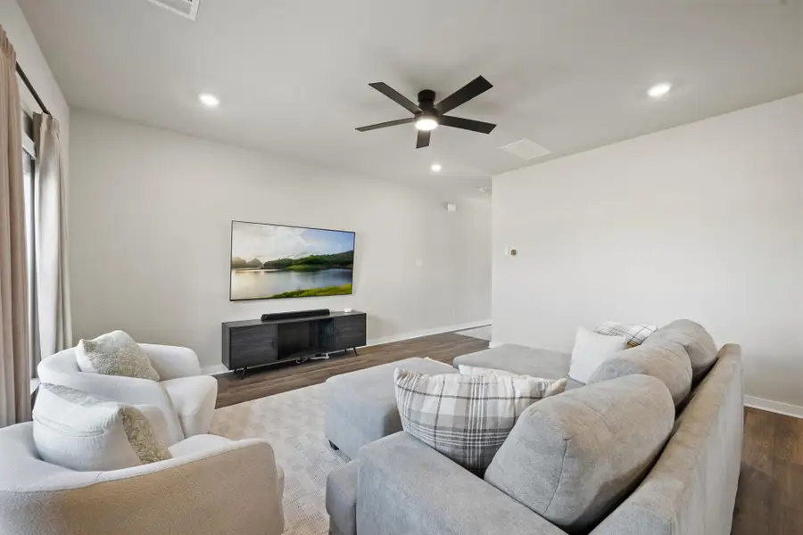Gleaming wood floors anchor this comfortable living area illuminated by subtle recessed lighting. Gleaming wood floors anchor this comfortable living area illuminated by subtle recessed lighting.