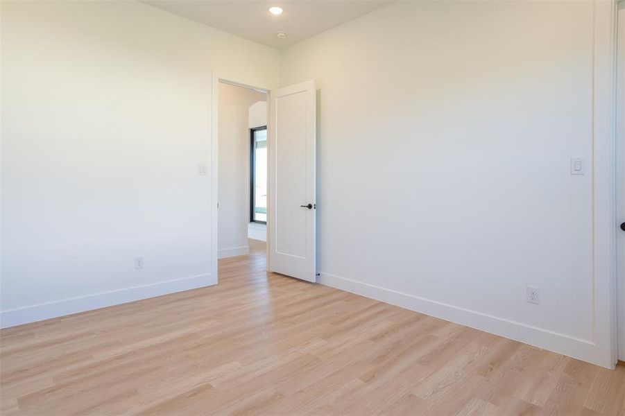 Empty room with light hardwood / wood-style flooring