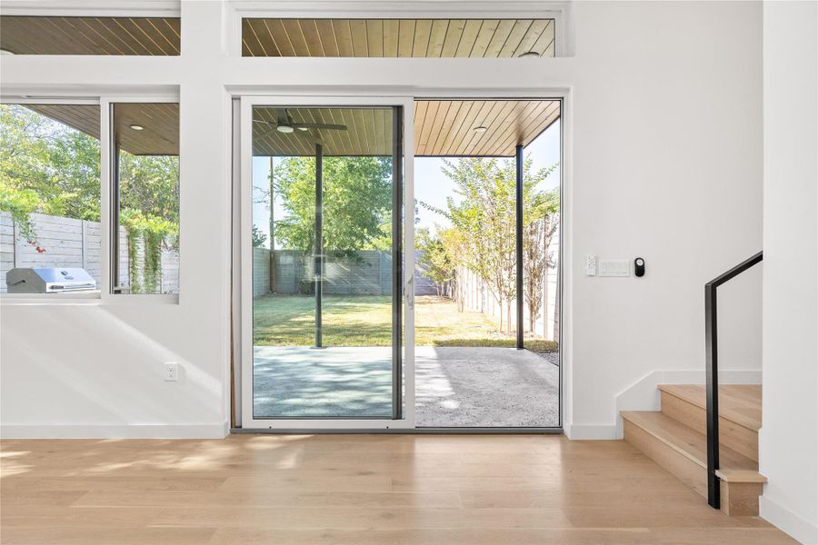 Doorway featuring wood finished floors, plenty of natural light, and stairs