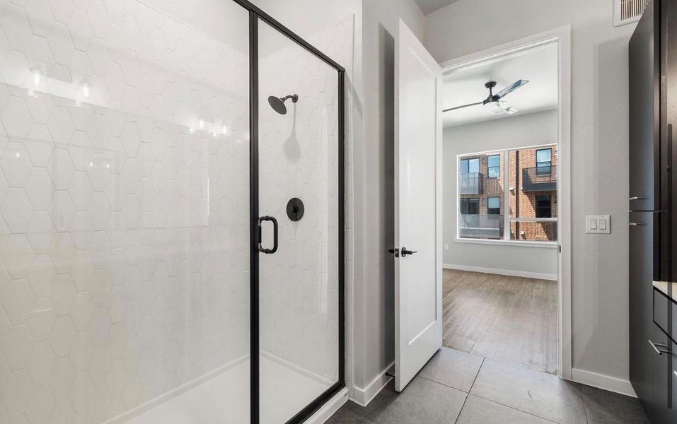 A glass-enclosed shower highlights this modern space with views into an adjacent room. A glass-enclosed shower highlights this modern space with views into an adjacent room.