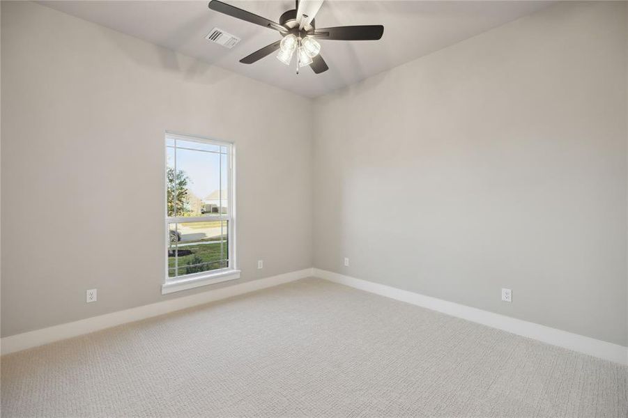 Carpeted spare room with ceiling fan