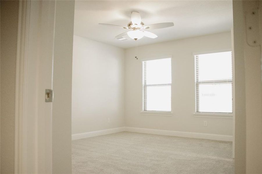 Carpeted spare room with ceiling fan