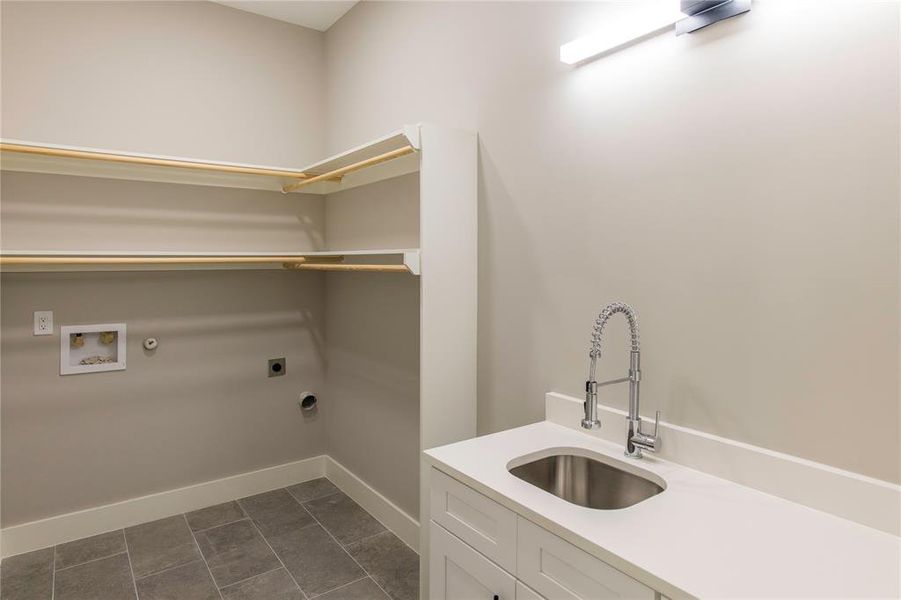 Laundry room featuring gas dryer hookup, hookup for a washing machine, electric dryer hookup, sink, and dark tile floors