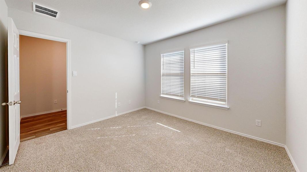 Spare room with light carpet and baseboards
