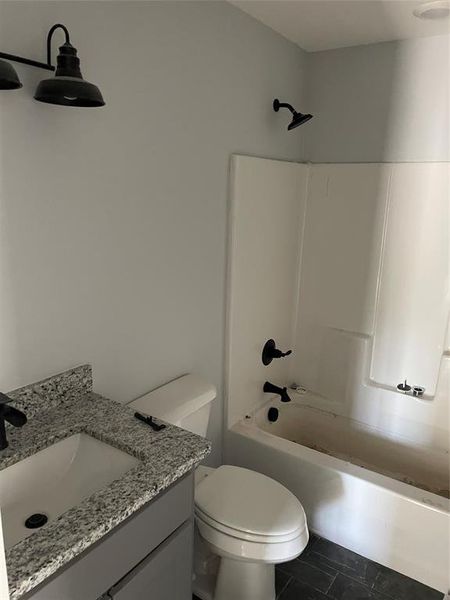 Full bathroom with vanity, shower / tub combination, toilet, and tile patterned flooring