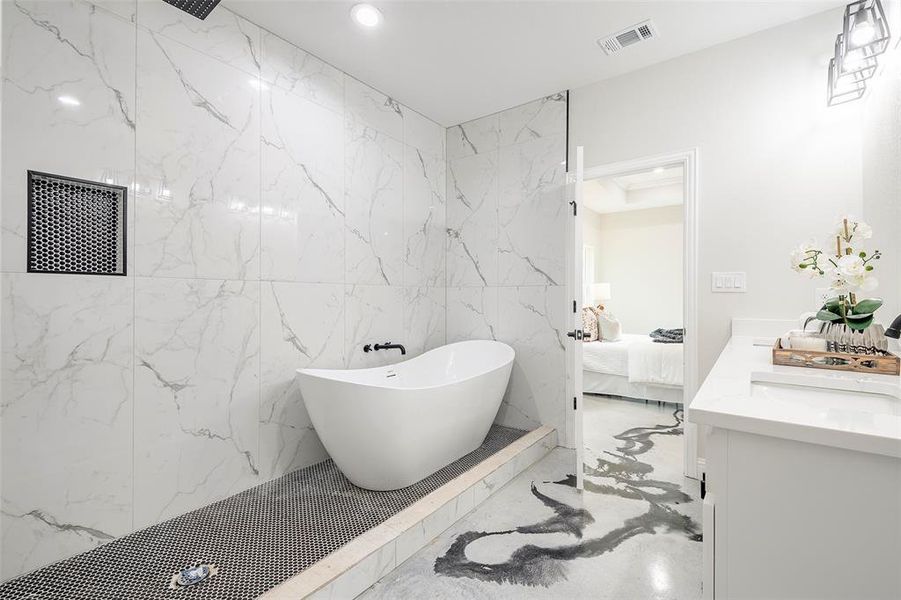 Bathroom with vanity, tile patterned floors, a bathing tub, and tile walls