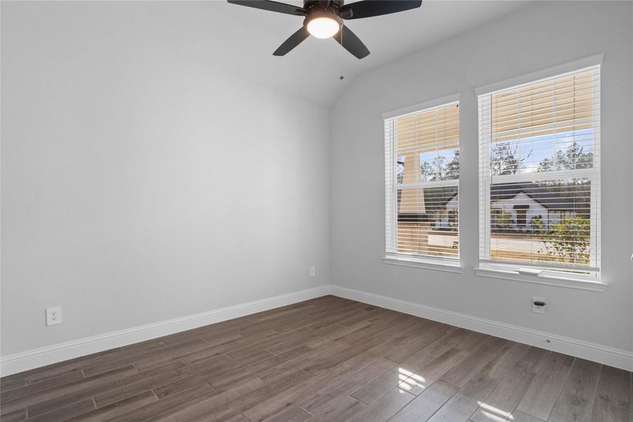 Tucked peacefully in the front of this home is this secondary bedroom. Featuring the wood-look tile flooring, ceiling fan large windows with faux wood blinds and an ample sized closet. Tucked peacefully in the front of this home is this secondary bedroom. Featuring the wood-look tile flooring, ceiling fan large windows with faux wood blinds and an ample sized closet.