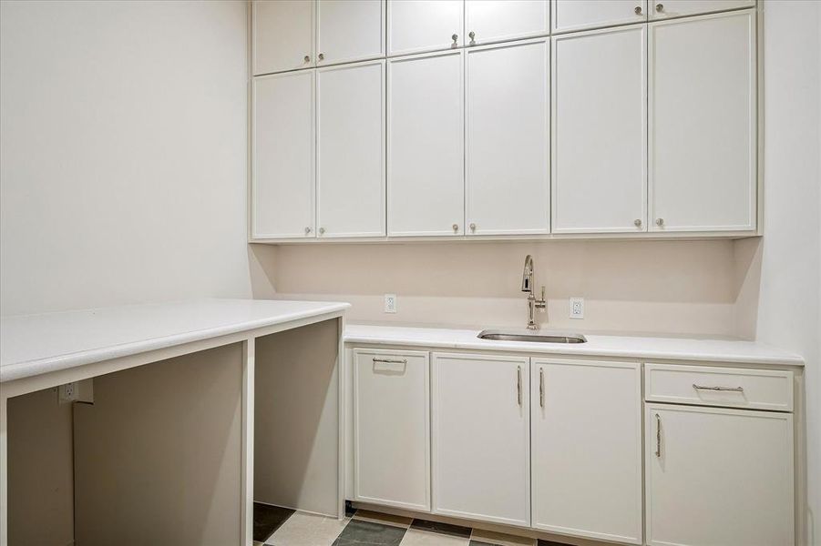 First-floor laundry, built-in cabinetry, utility sink, stone countertop First-floor laundry, built-in cabinetry, utility sink, stone countertop