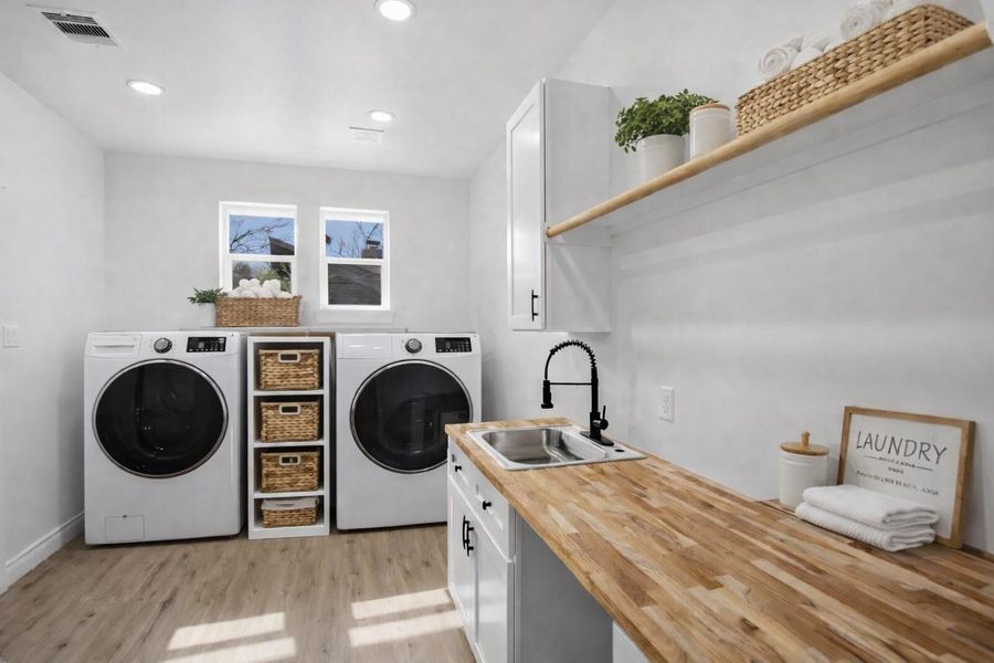 Designer laundry room with built-in sink and direct access to the primary suite.