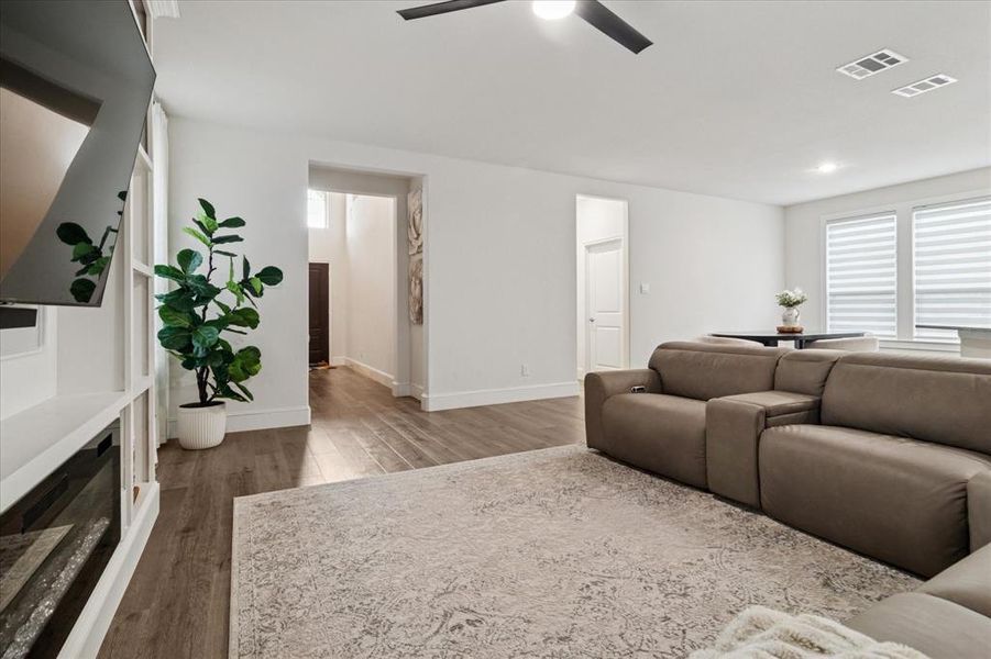 Living room with dark wood finished floors, ceiling fan, and recessed lighting Living room with dark wood finished floors, ceiling fan, and recessed lighting