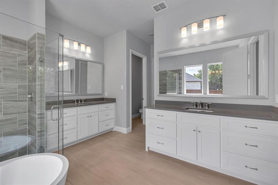 Full bathroom featuring toilet, shower with separate bathtub, and vanity