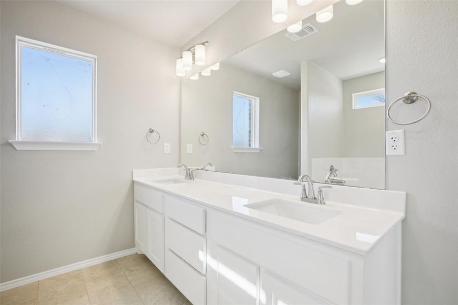 Bathroom featuring double vanity and light tile patterned flooring