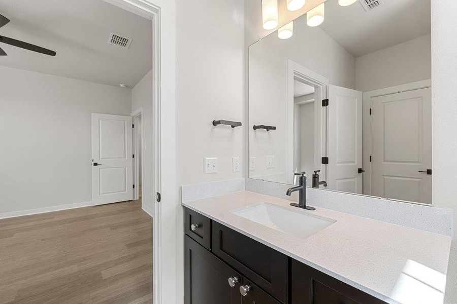Bathroom with vanity, light wood-style floors, and ceiling fan