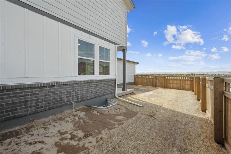 A building with a fence and a dirt yard.