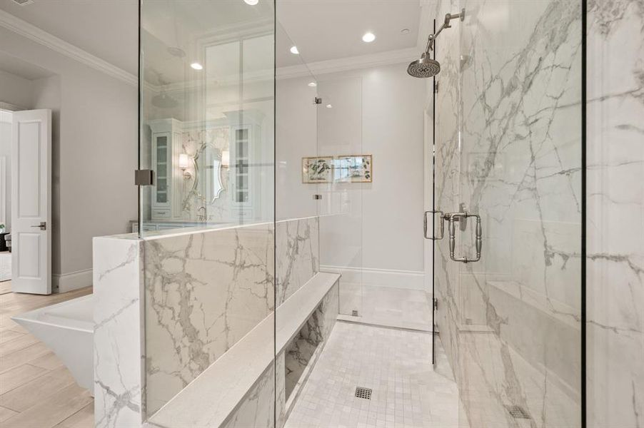Bathroom with a marble finish shower, ornamental molding, recessed lighting, and a freestanding tub Bathroom with a marble finish shower, ornamental molding, recessed lighting, and a freestanding tub