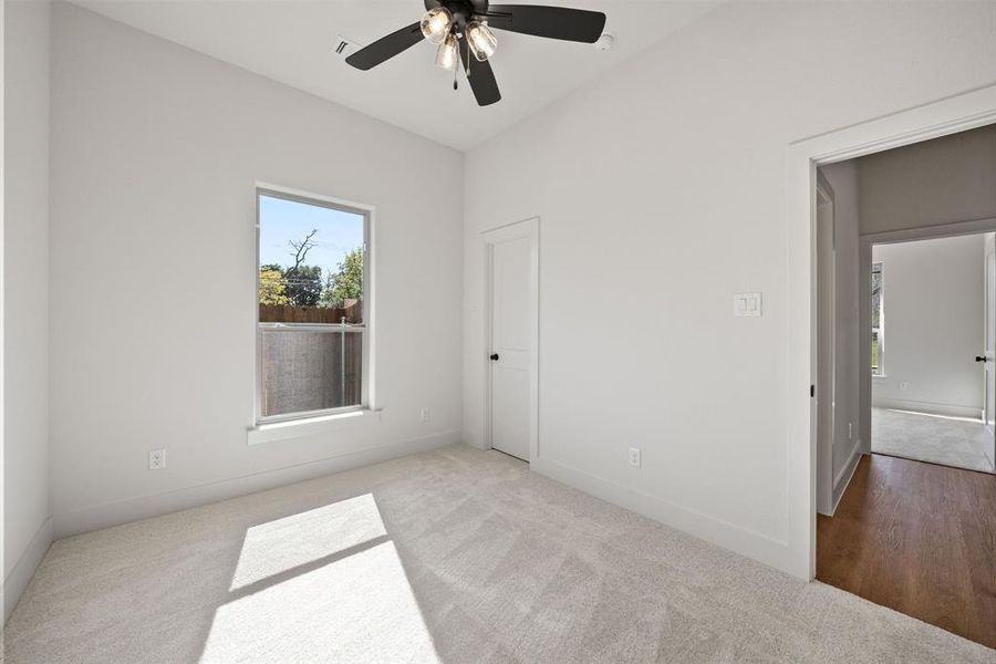 Unfurnished bedroom with carpet floors, multiple windows, and ceiling fan