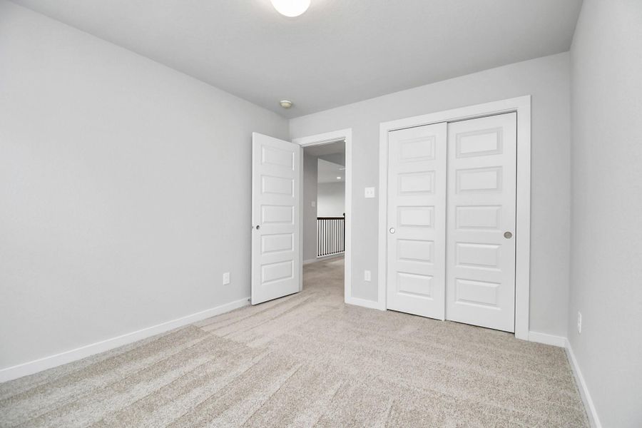 Generously sized secondary bedrooms, complete with spacious closets and soft, inviting carpeting. Sample photo of completed home with similar floor plan. Actual colors and selections may vary.