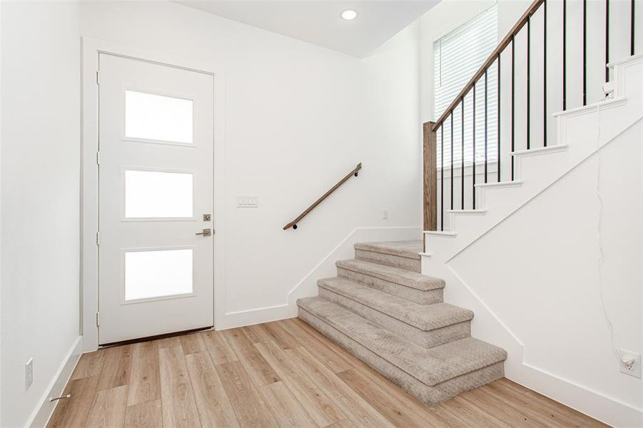 Entrance foyer featuring stairs, light wood finished floors, and recessed lighting