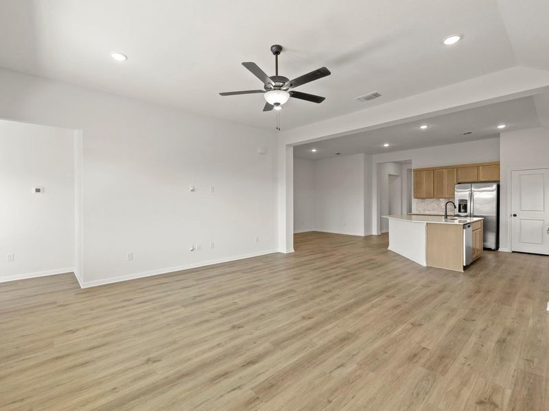 Open-concept living area featuring wood-finish flooring, recessed lighting, and a modern ceiling fan