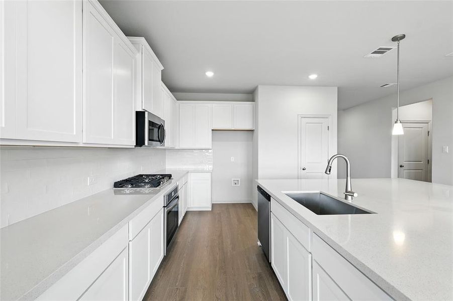 Kitchen featuring hanging light fixtures, white cabinetry, dark wood finished floors, backsplash, and recessed lighting