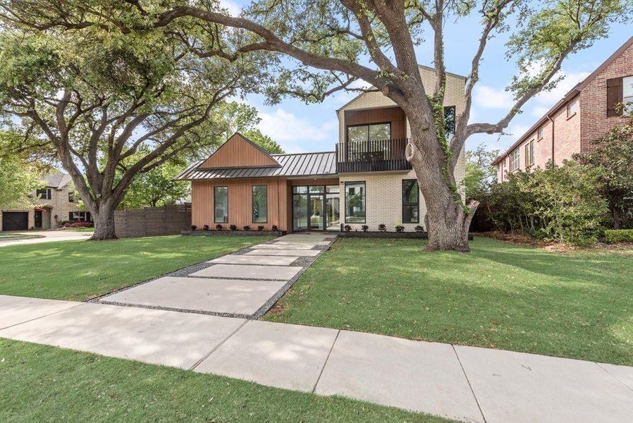 Clean lines, layered materials, and natural textures come together in a calm, textured modern design—set beneath a canopy of mature trees.
