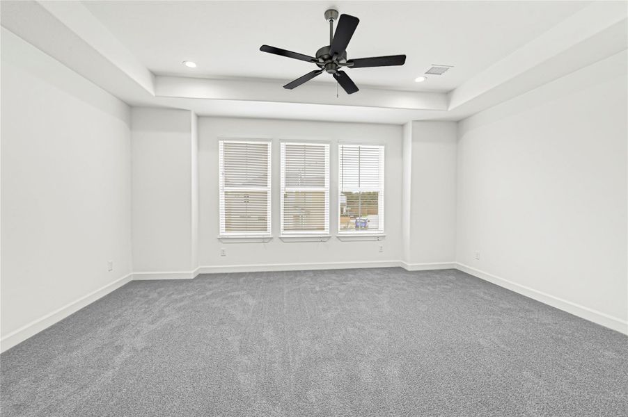 Spacious, bright room with a modern ceiling fan, recessed lighting, and large windows allowing natural light. Neutral carpet and walls create a clean, versatile space. Spacious, bright room with a modern ceiling fan, recessed lighting, and large windows allowing natural light. Neutral carpet and walls create a clean, versatile space.