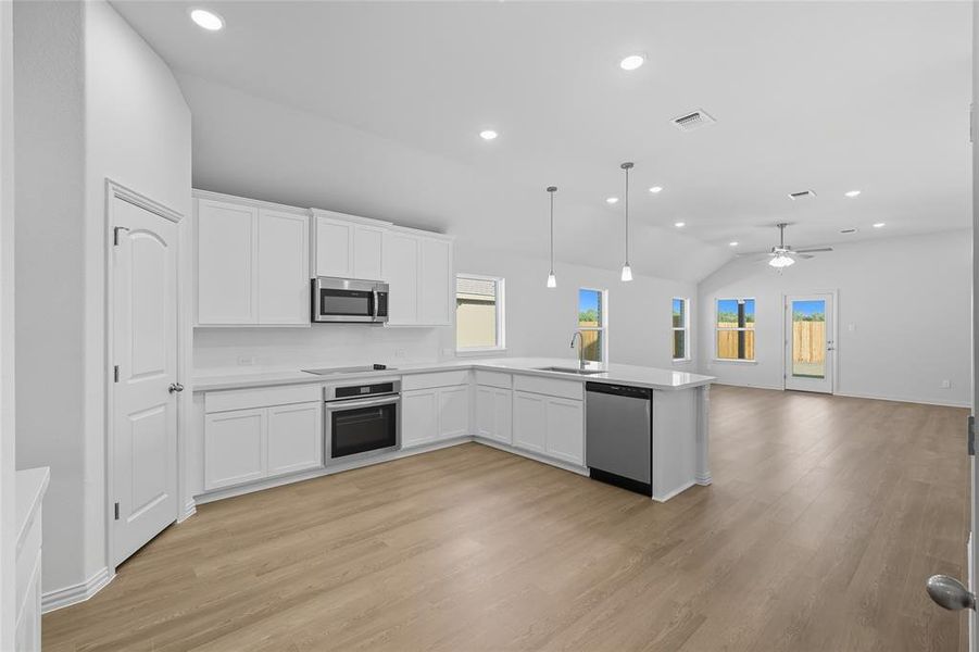 Kitchen featuring white cabinetry, pendant lighting, recessed lighting, open floor plan, and a ceiling fan Kitchen featuring white cabinetry, pendant lighting, recessed lighting, open floor plan, and a ceiling fan