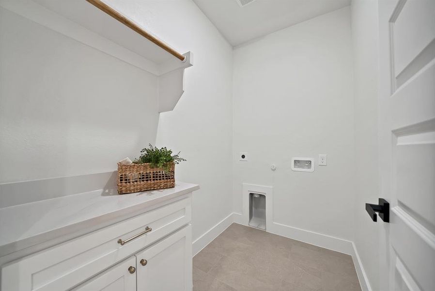 Washroom with gas dryer hookup, hookup for an electric dryer, hookup for a washing machine, and light tile patterned floors Washroom with gas dryer hookup, hookup for an electric dryer, hookup for a washing machine, and light tile patterned floors