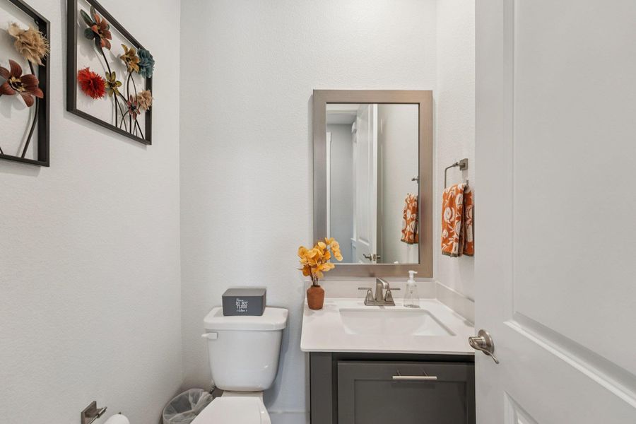 Chic powder bath featuring designer lighting, quartz vanity, and stylish finishes that make a lasting impression on guests.
