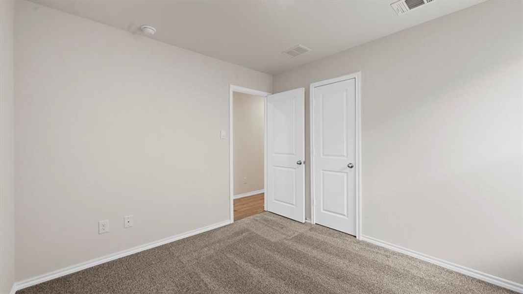 Unfurnished bedroom with carpet floors and baseboards