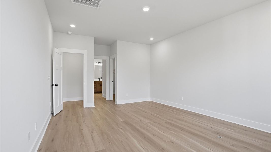 Superior design meets vibrant comfort in this primary suite with hardwood floors and walk-in closet located in Greenville, SC