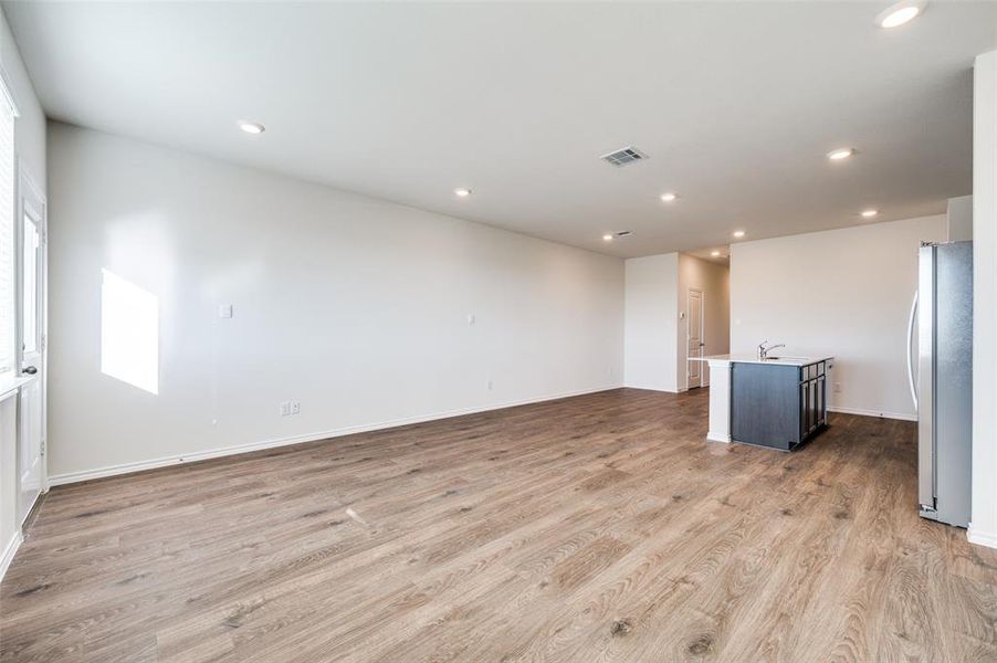 Unfurnished living room with sink and light hardwood / wood-style flooring