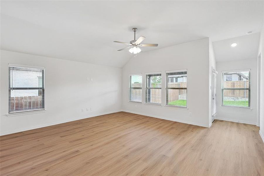 Empty room featuring ceiling fan, light hardwood / wood-style floors, and vaulted ceiling