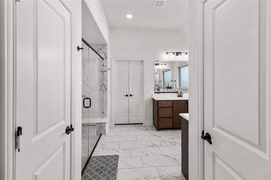 Bathroom featuring a marble finish shower, light marble finish floors, vanity, and recessed lighting