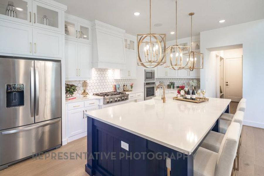 Kitchen with a chandelier, stainless steel appliances, decorative backsplash, and light wood-type flooring Kitchen with a chandelier, stainless steel appliances, decorative backsplash, and light wood-type flooring
