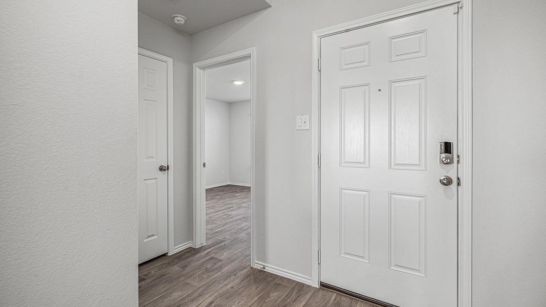 Hallway featuring dark wood finished floors and baseboards Hallway featuring dark wood finished floors and baseboards