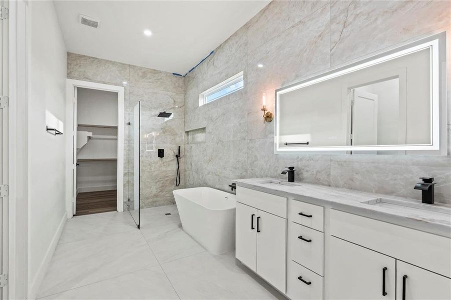 Modern bathroom featuring a dual vanity with white cabinetry and black hardware
