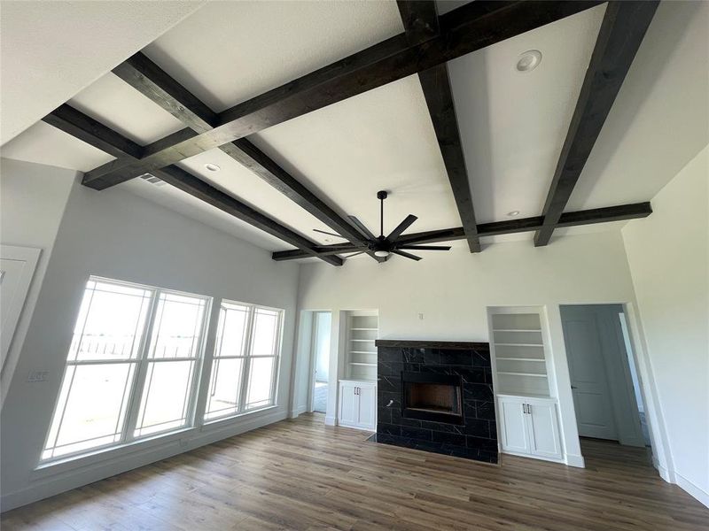 Unfurnished living room featuring beam ceiling, a high end fireplace, wood finished floors, recessed lighting, and ceiling fan Unfurnished living room featuring beam ceiling, a high end fireplace, wood finished floors, recessed lighting, and ceiling fan