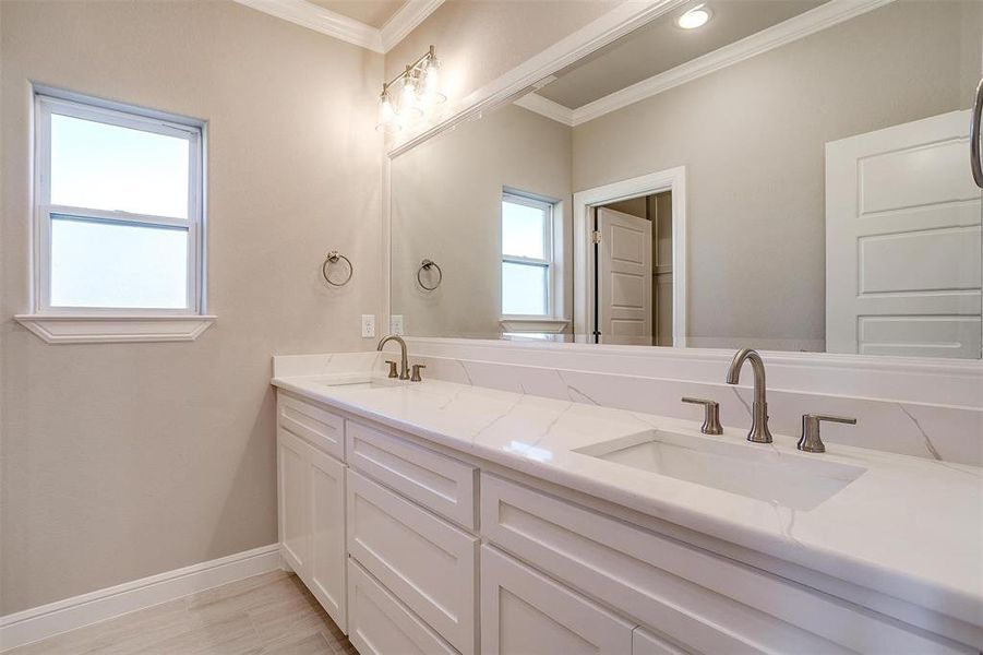 Bathroom with ornamental molding and vanity