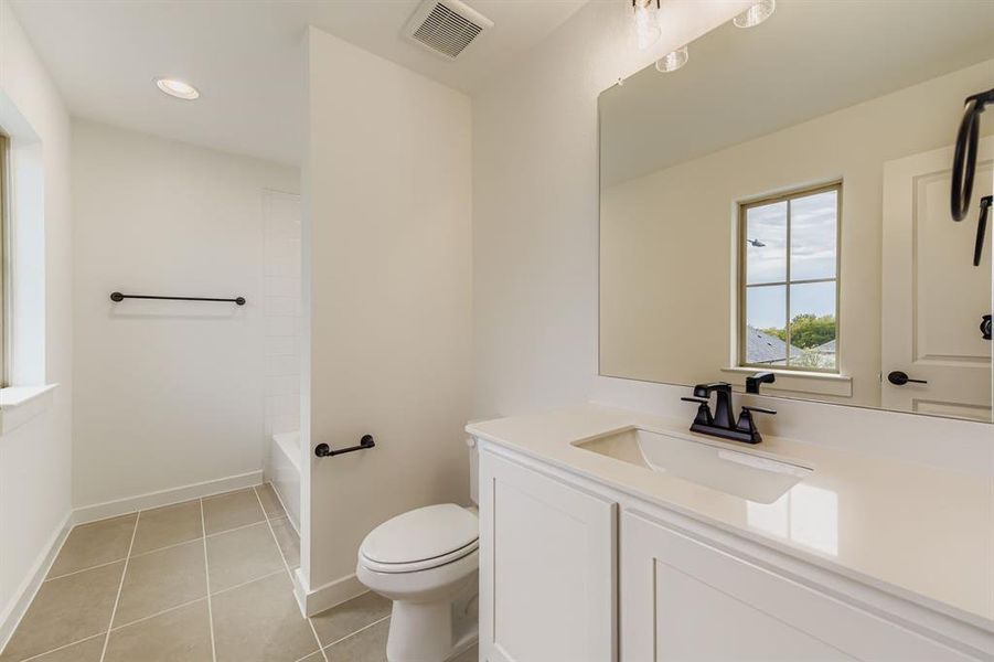 Bathroom featuring vanity, light tile patterned flooring, bathing tub / shower combination, and recessed lighting Bathroom featuring vanity, light tile patterned flooring, bathing tub / shower combination, and recessed lighting
