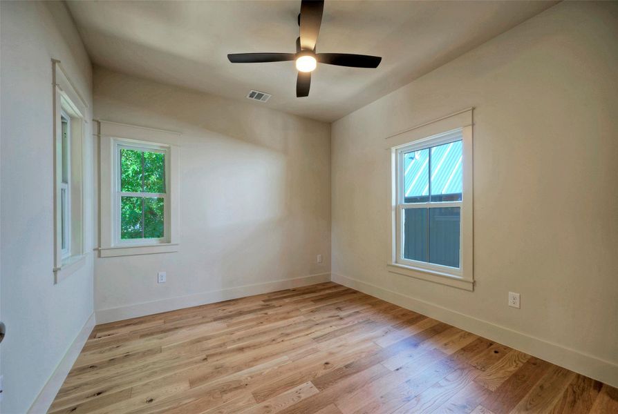 Bedroom 3 with warm hardwood floors and ample natural light.