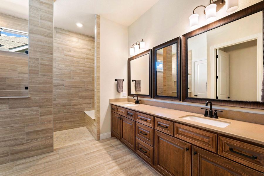 Dual vanity with rich cabinetry and an adjacent tiled walk-in shower elevate this bathroom. Dual vanity with rich cabinetry and an adjacent tiled walk-in shower elevate this bathroom.