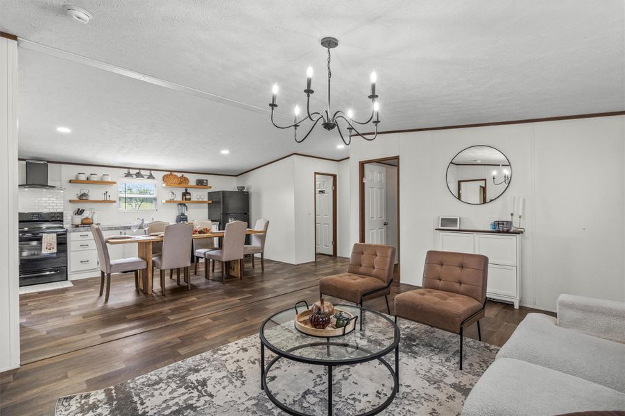 Living area with ornamental molding, dark wood-type flooring, a chandelier, a textured ceiling, and recessed lighting