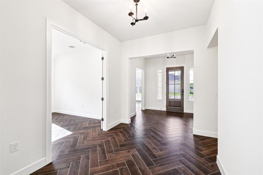 Entryway featuring a chandelier and baseboards Entryway featuring a chandelier and baseboards