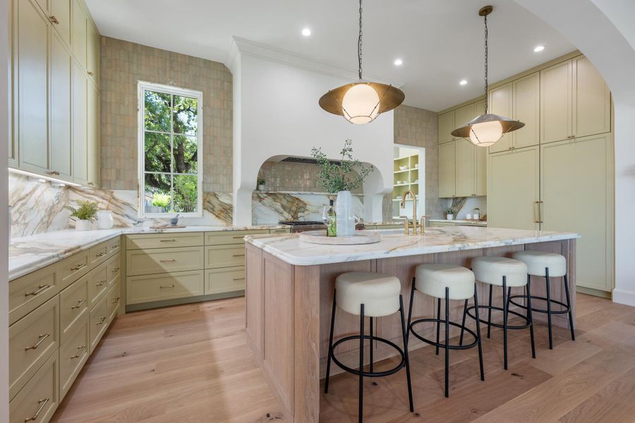 Custom cabinetry and premium stone surfaces define this meticulously crafted culinary space.
