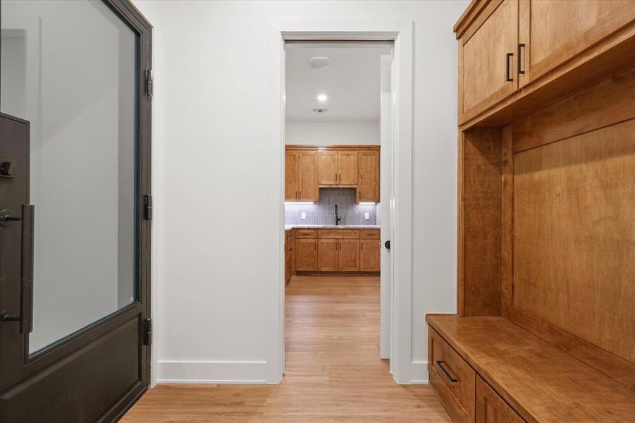 Mudroom featuring light wood-type flooring and a sink
