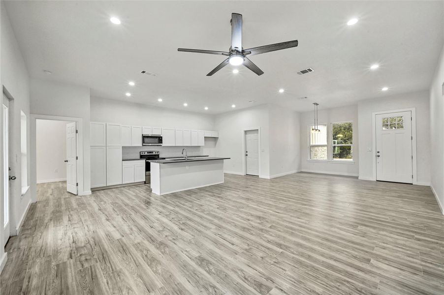 Unfurnished living room with recessed lighting, a ceiling fan, and light wood-type flooring