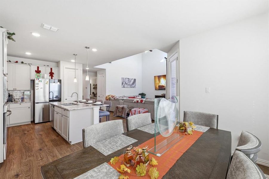 Dining area with dark wood-style floors and recessed lighting