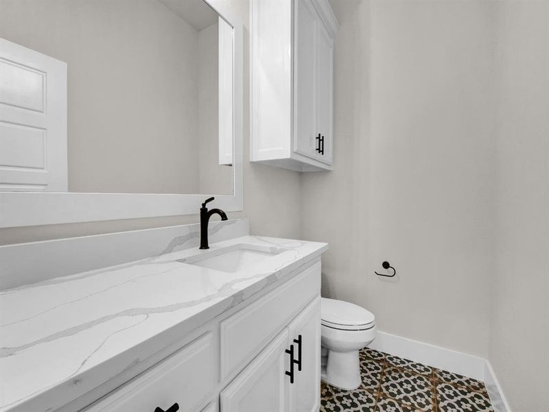 Bathroom featuring vanity and dark tile patterned flooring